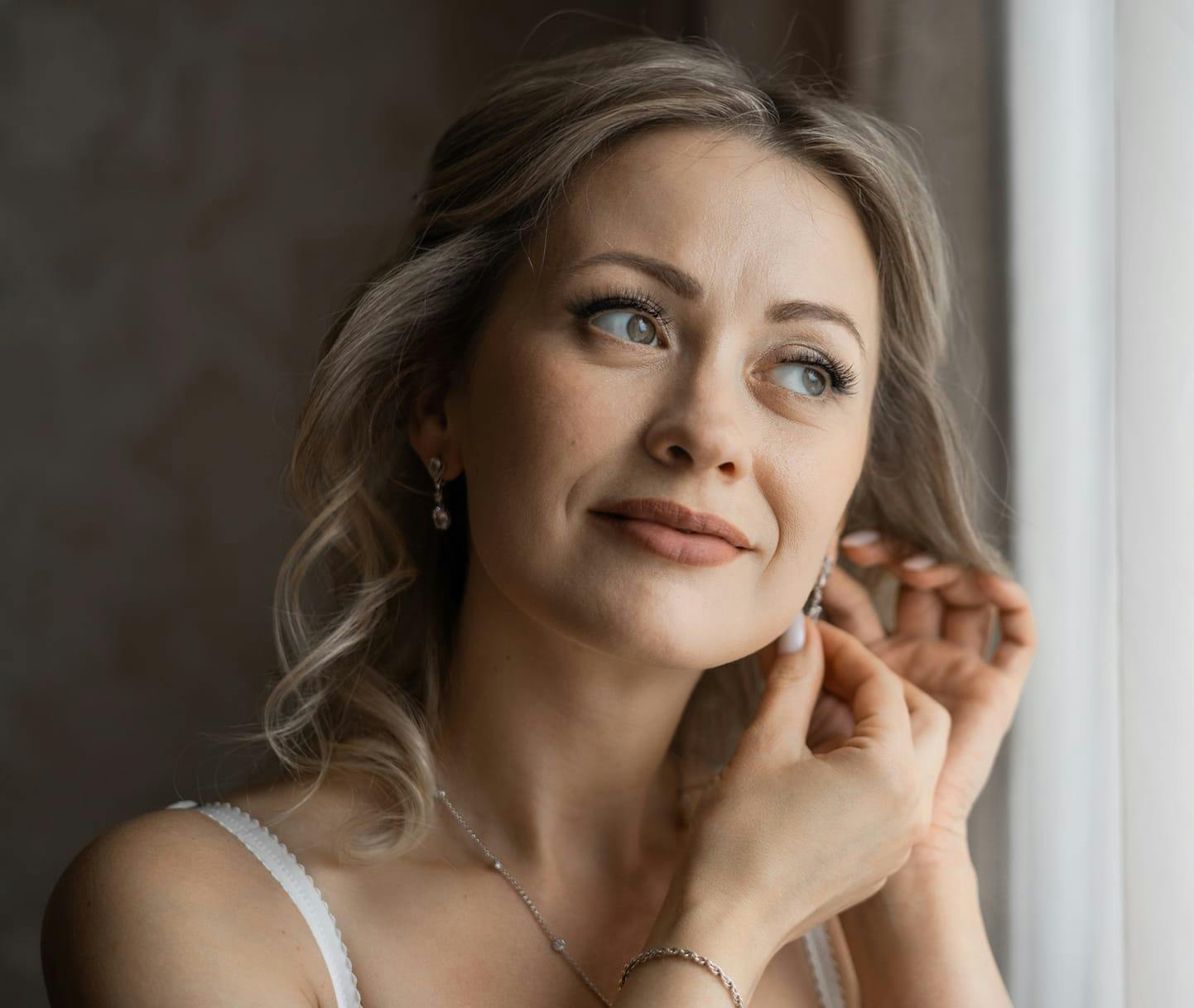 Woman putting on earrings