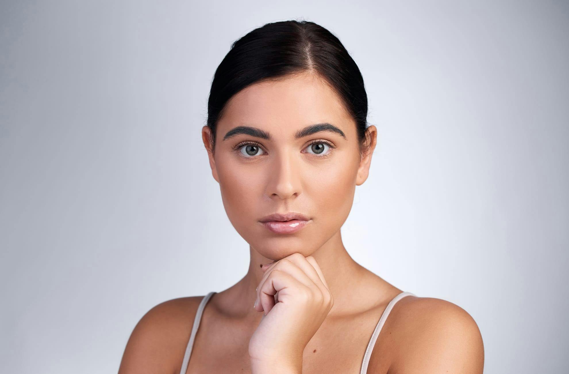 woman looking forward with her hand under her chin