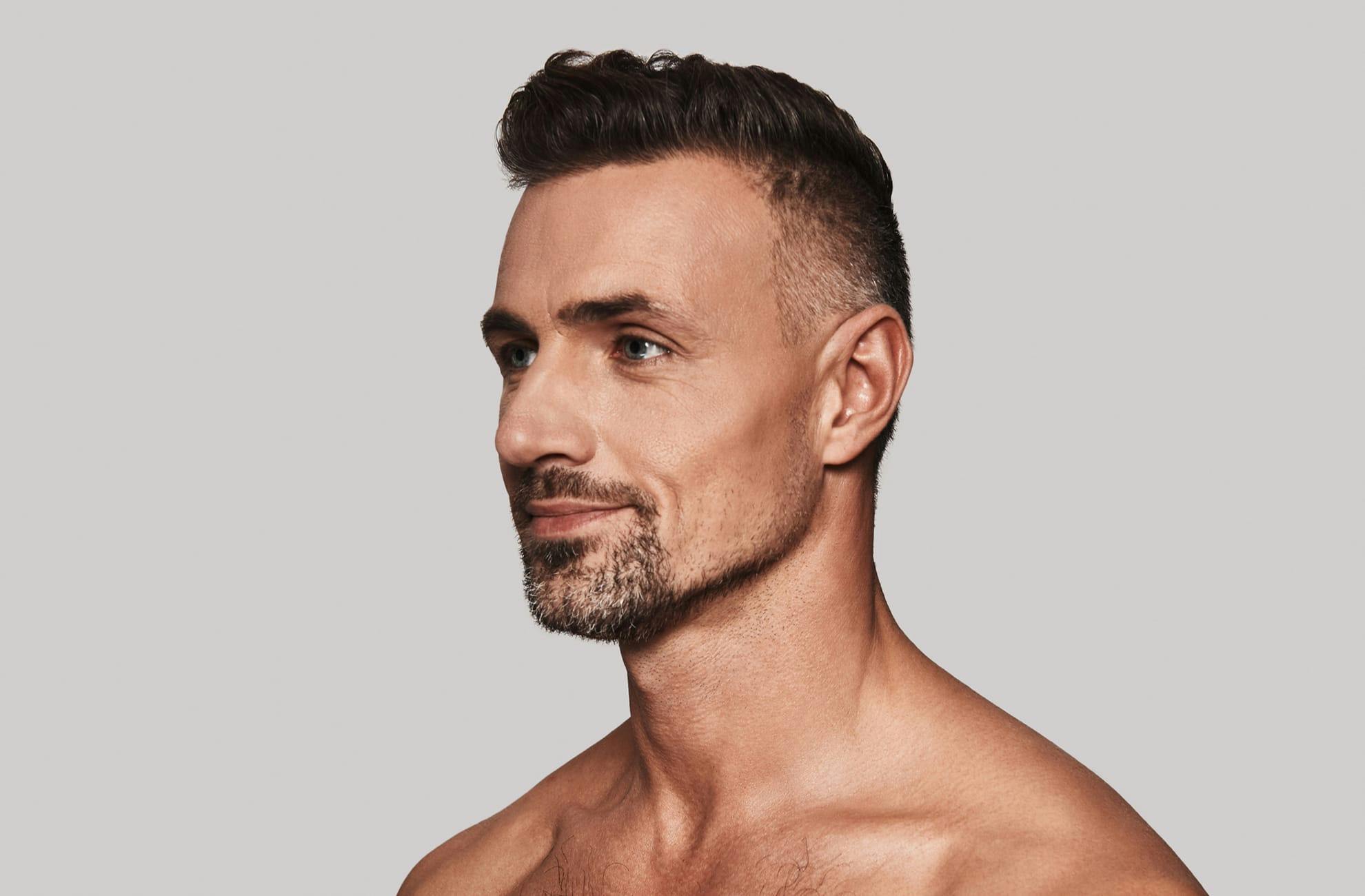 man with styled hair and goatee without shirt looking to the left