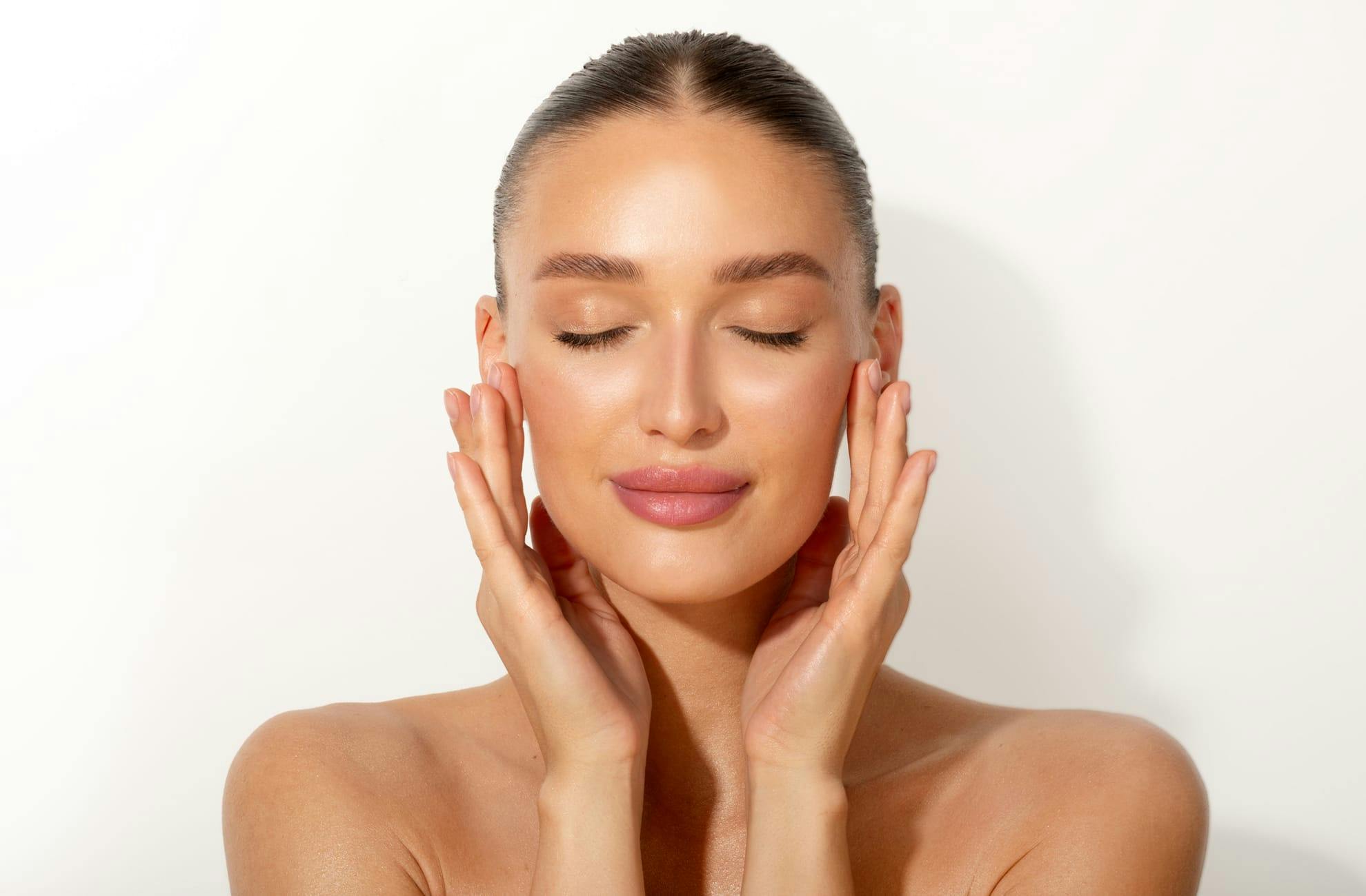 woman with clear skin touching her face