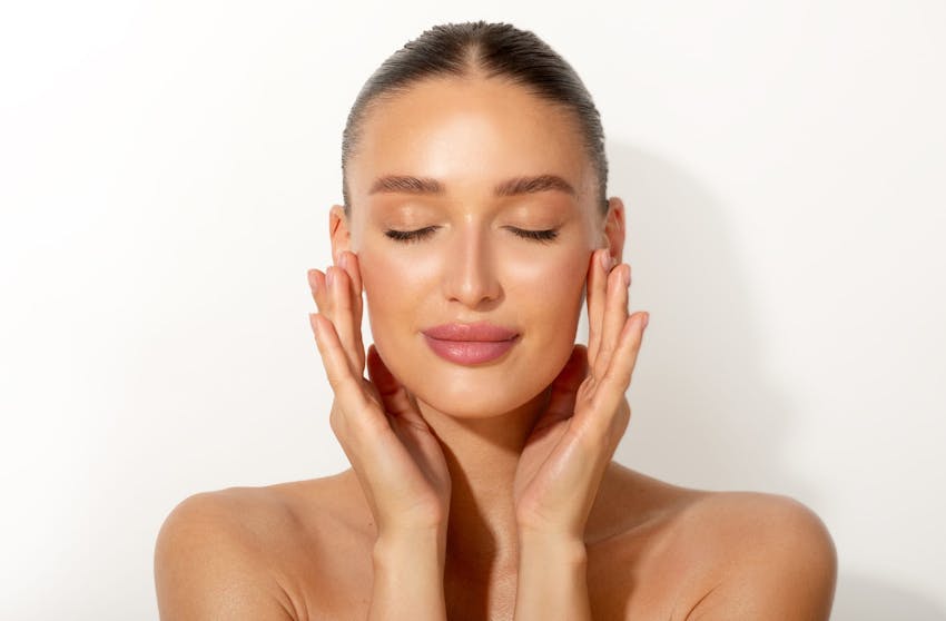 woman with clear skin touching her face