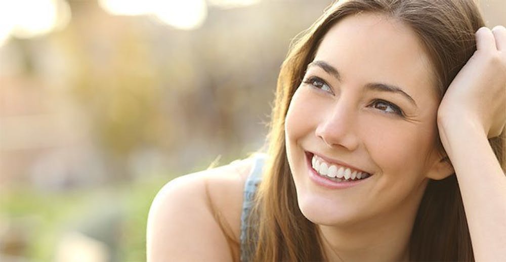 Confident young woman smiling outside