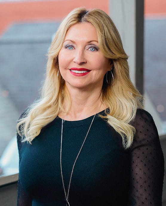 woman with blonde hair wearing a black blouse