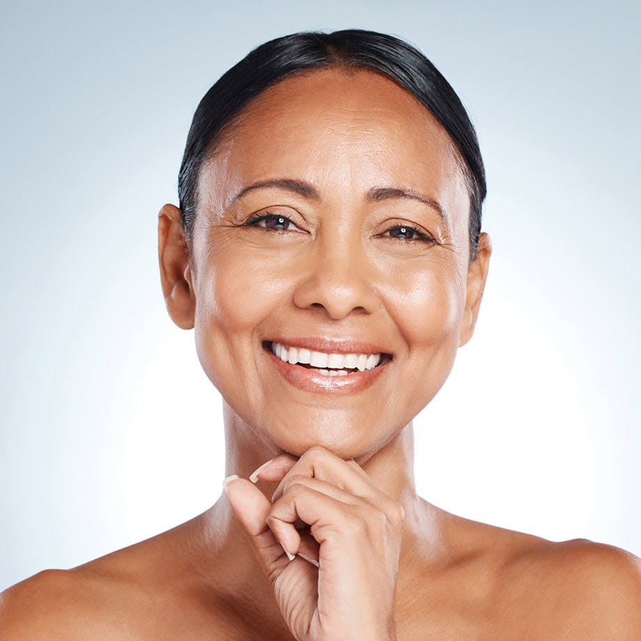 woman smiling and resting her face on her chin
