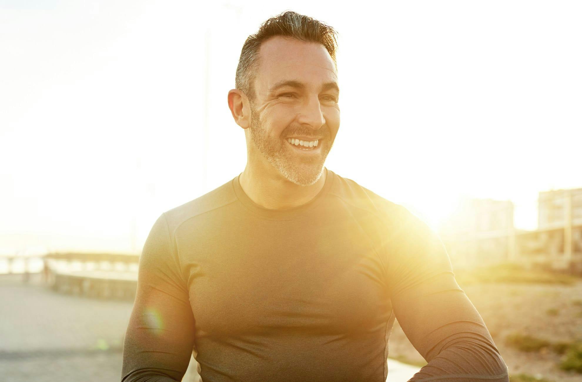 man posing with shirt off wearing dark pants