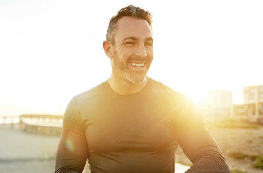man posing with shirt off wearing dark pants