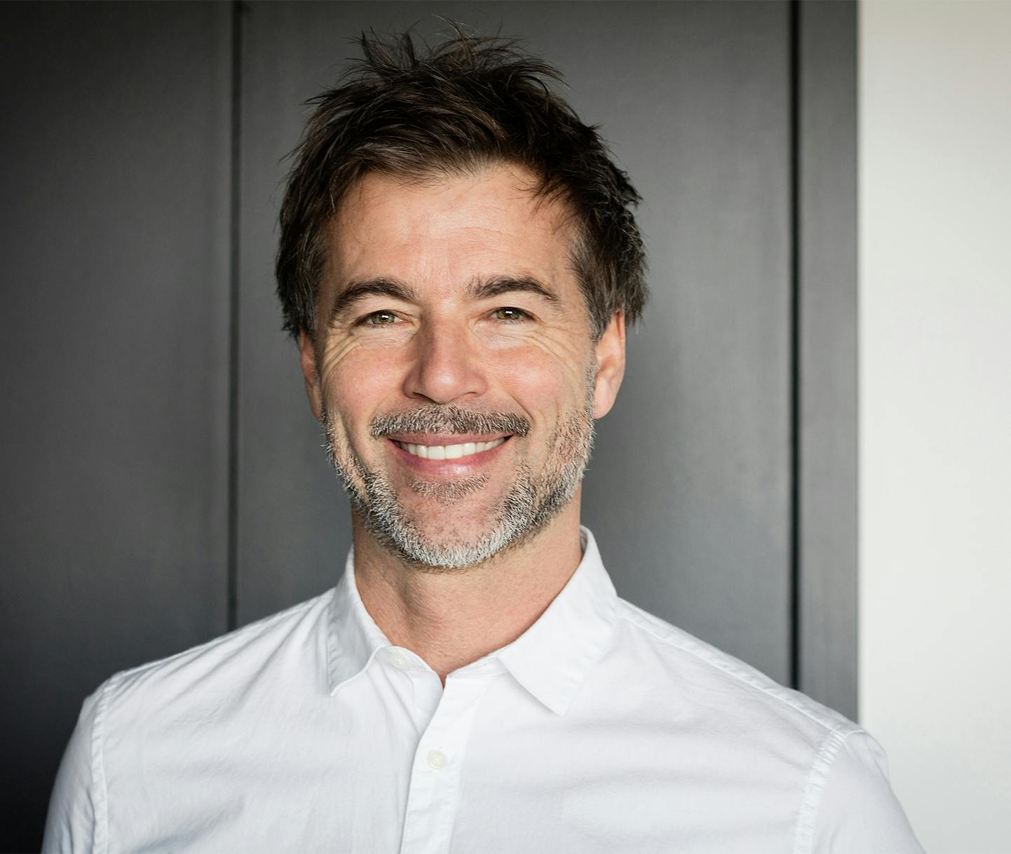 Man smiling with hand on neck