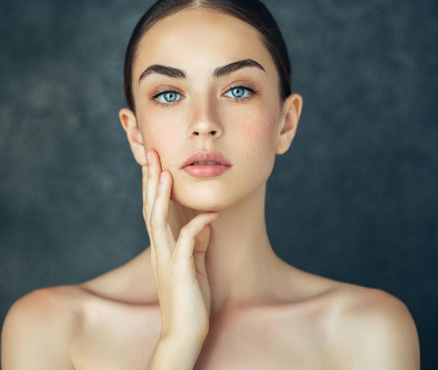 woman laying on her stomach on a bed keeping her head up with her hands