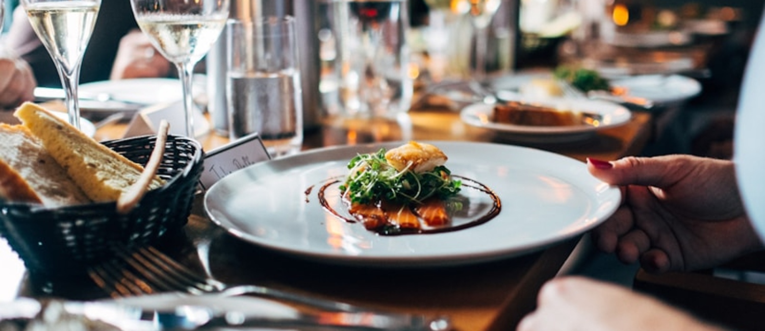 Gourmet food plated in a restaurant with wine glasses