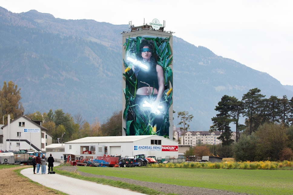 Die Wächterin der Drei Bünde: Landmark-Mural am Mühleturm in Chur Eingebettet in die alpine Landschaft rund um die Plessur erhebt sich der Mühleturm als neues visuelles Wahrzeichen von Chur. Das monumentale Mural von Bane verbindet Geschichte, Identität und Gegenwart: Die Wächterin mit ihren drei Lichtquellen steht symbolisch für Gemeinschaft, Fortschritt und die Wurzeln Graubündens. Ein prägnantes Beispiel für Kunst im öffentlichen Raum mit starker regionaler Verankerung. #Chur #Graubünden #UrbanArtSchweiz