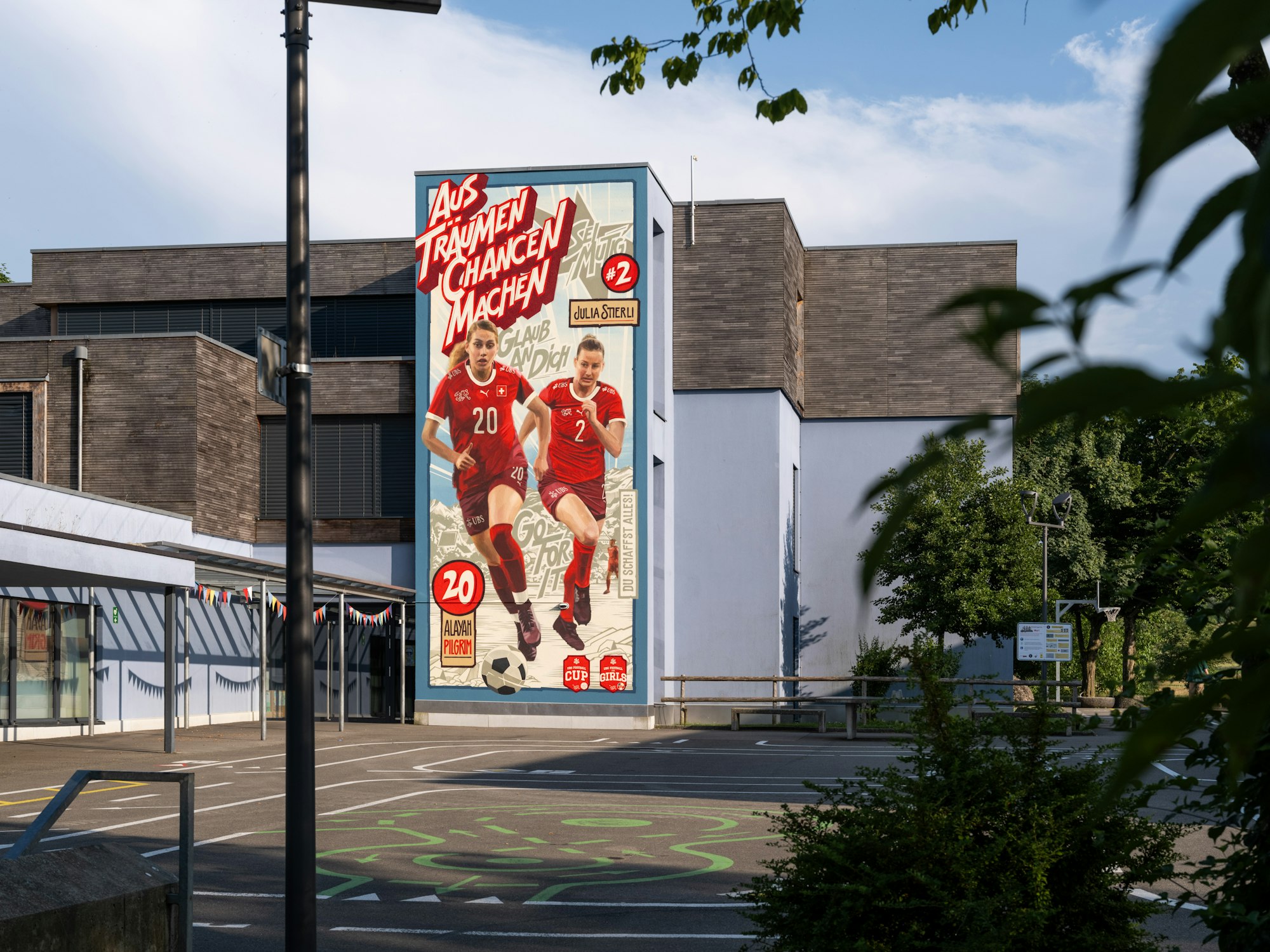 Wandgemälde mit Fussballerinnen Pilgrim und Stierli auf Schulhaus in Muri AG, UBS Kampagne zur Women’s Euro 2025.
