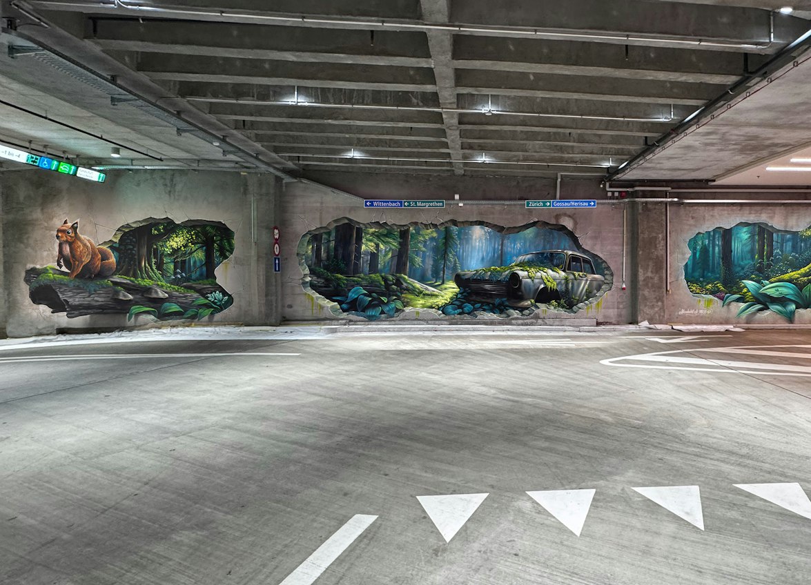 Eine Betonwand in einem Parkhaus mit realistischen Wandmalereien der WAND AG, die einen Fuchs, ein verlassenes Auto und eine Waldszene darstellen – so gemalt, dass der Eindruck entsteht, die Wand habe Öffnungen nach draussen. Diese faszinierende Street-Art verwandelt den Raum in ein eindringliches visülles Erlebnis.