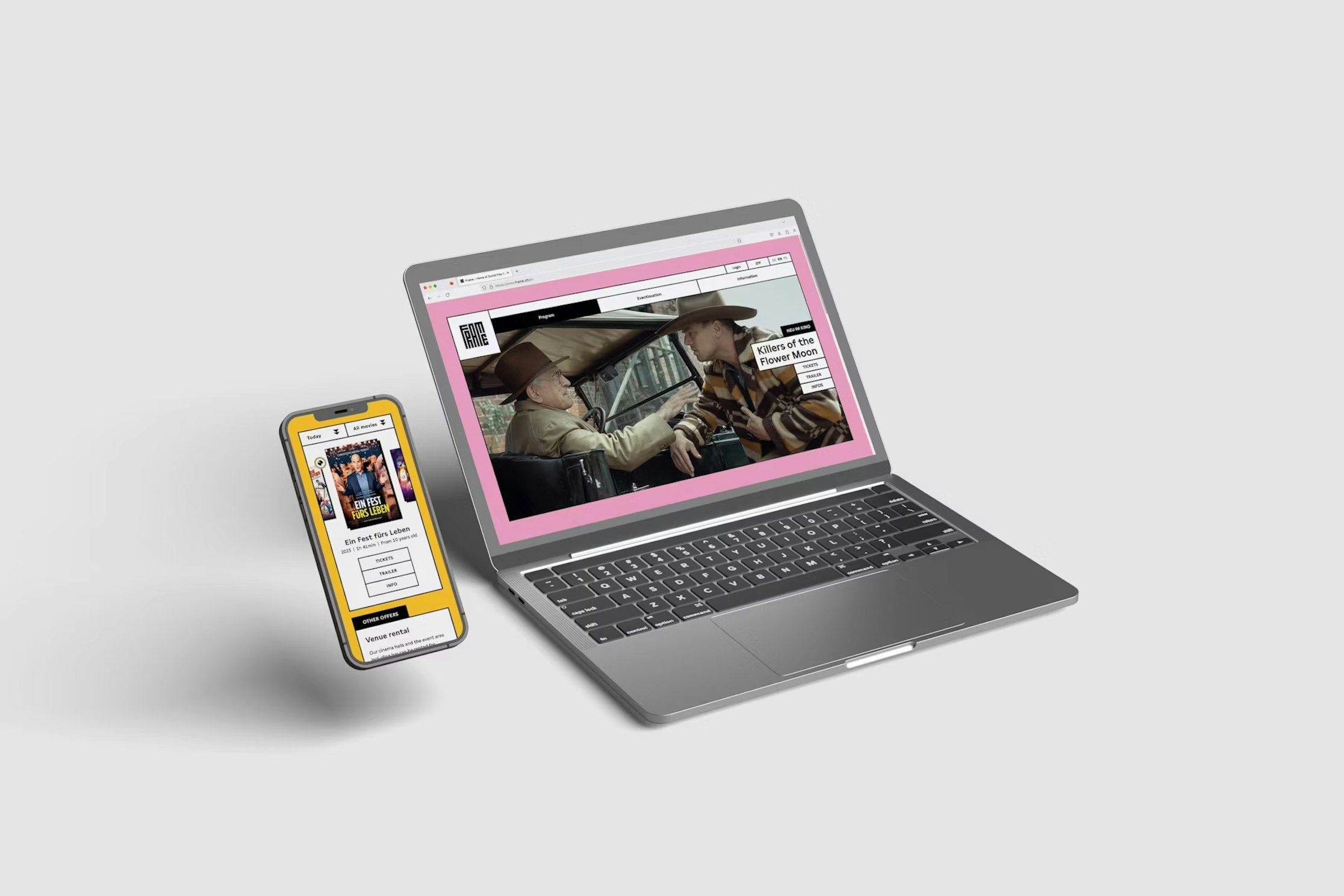 Ein Smartphone und ein Laptop auf einer hellgrauen Fläche. Das Smartphone zeigt eine bunte Webseite, der Laptop eine Szene aus einem Filmklassiker mit rosa Rahmen. Beide Bildschirme sind nach vorne gerichtet.