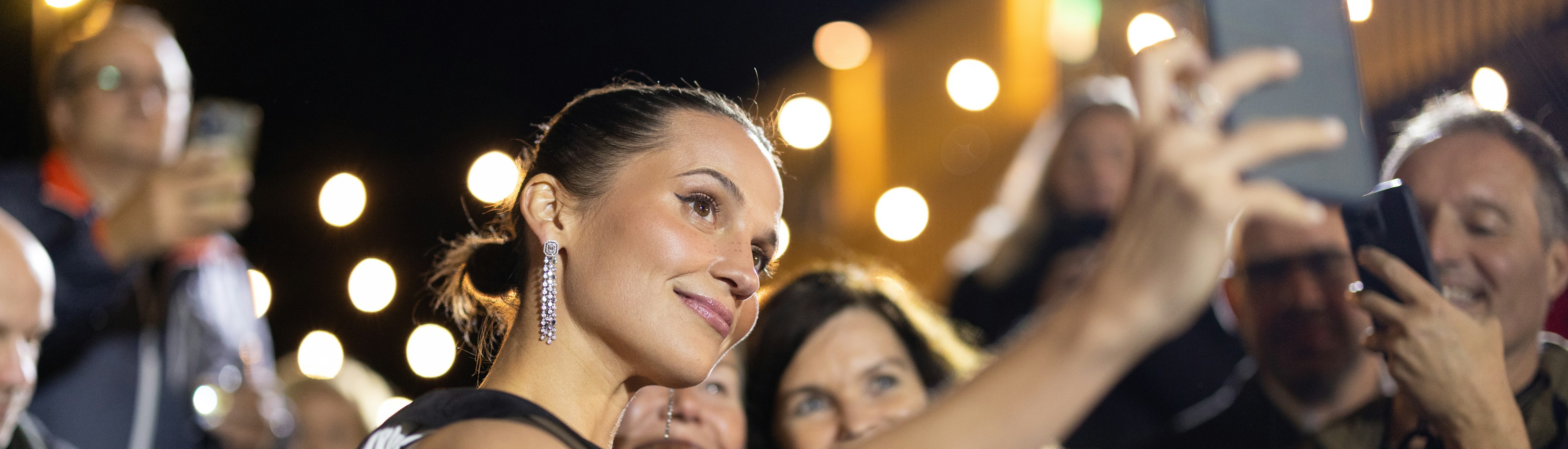 Frau mit Handy wo mit Gäste ein Selfie macht