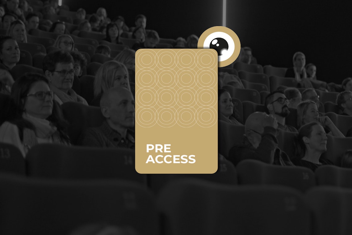 Eine Gruppe von Menschen sitzt in einem Kino. In der Bildmitte ist eine große, halbtransparente Pre-Access-Pass-Grafik eingeblendet. Das Publikum scheint einen Film oder eine Präsentation anzusehen.
