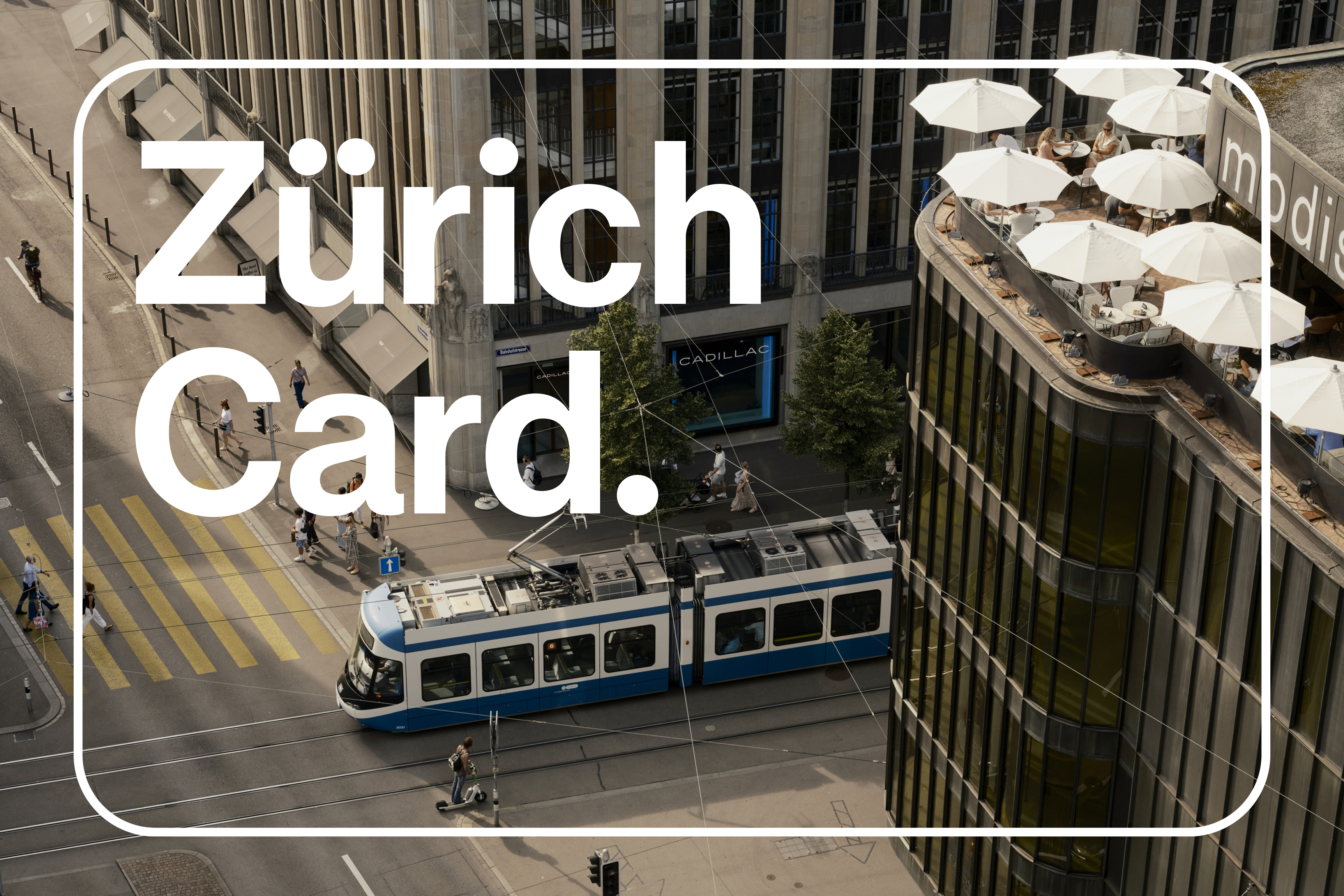 Luftaufnahme einer Straße in Zürich mit einer blau-weißen Straßenbahn, einem Zebrastreifen und einem modernen Gebäude mit einer Dachterrasse und weißen Sonnenschirmen. Großer Text liest Zürich Card.