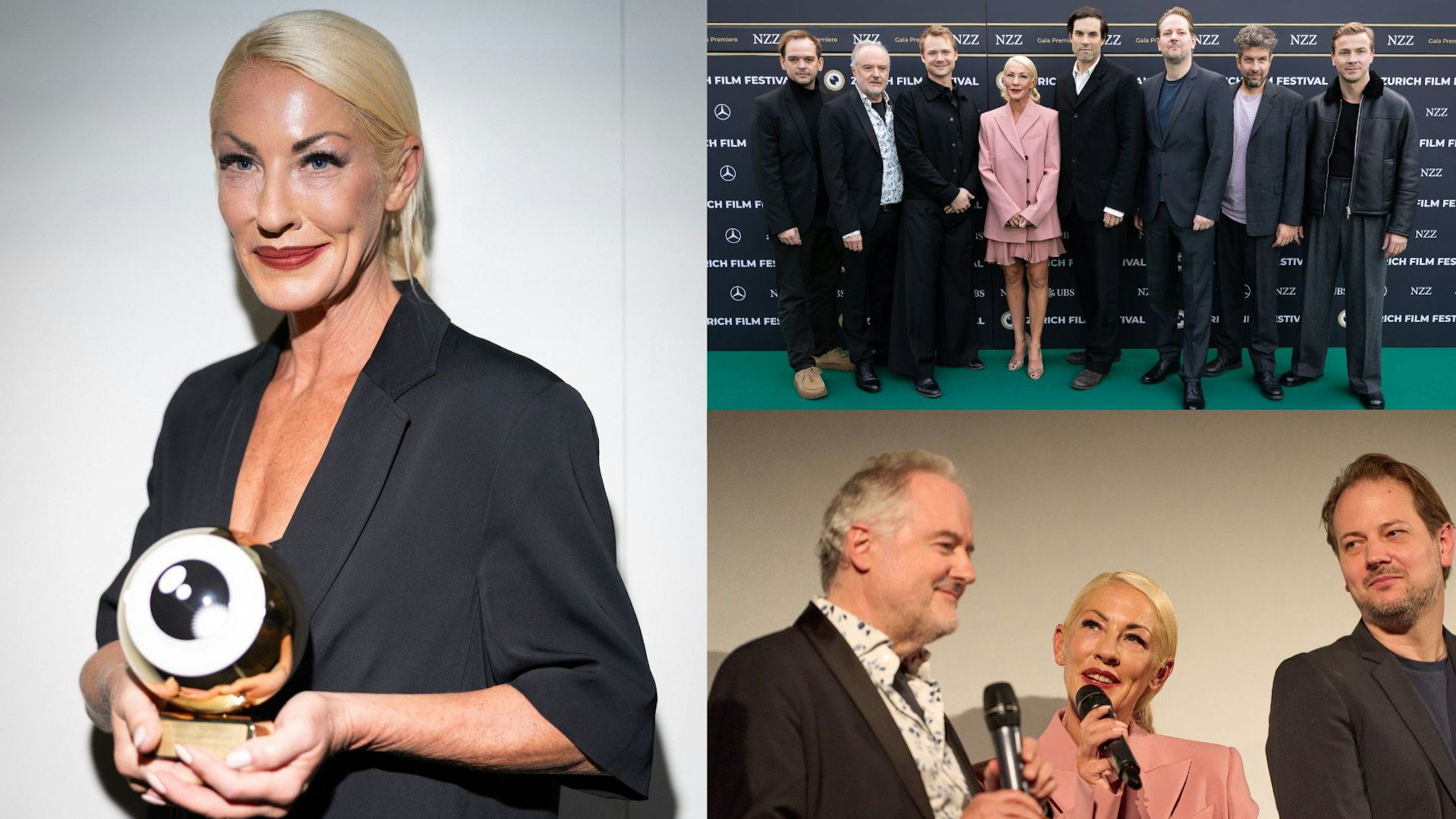 Eine blonde Frau in einem schwarzen Outfit hält eine Trophäe in Form eines Auges, posiert mit einer Gruppe in formeller Kleidung auf einem grünen Teppich und spricht auf der Bühne mit zwei Männern.