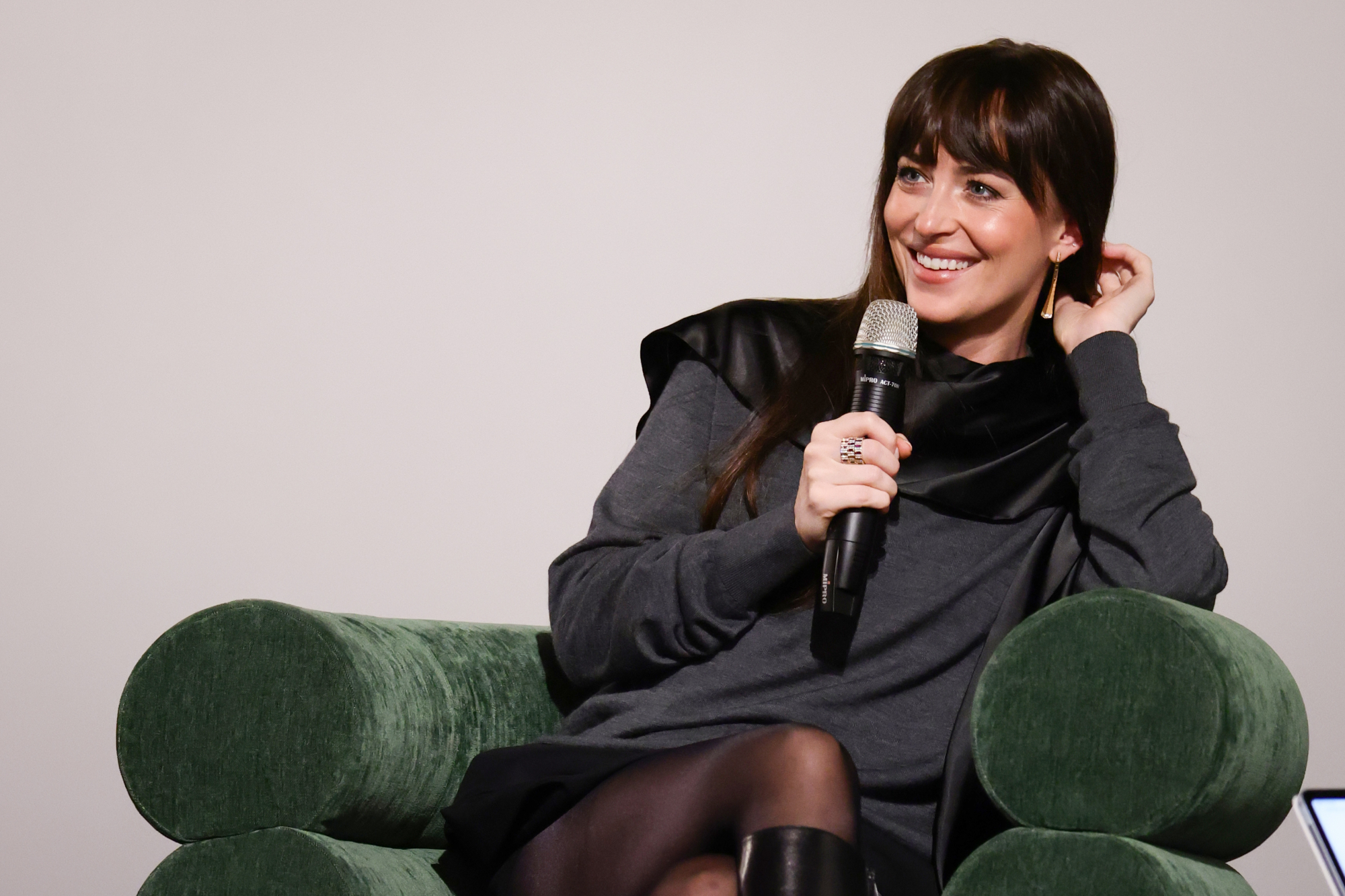 Dakota Johnson im Interview auf eine grünen Sessel
