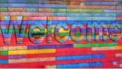 Color photo of a large, multicolored Welcome sign