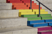 Color photo of a staircase with the steps painted the colors of the rainbow