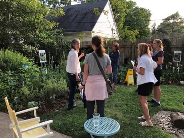 Photograph of a group of people in a backyard learning about native plants