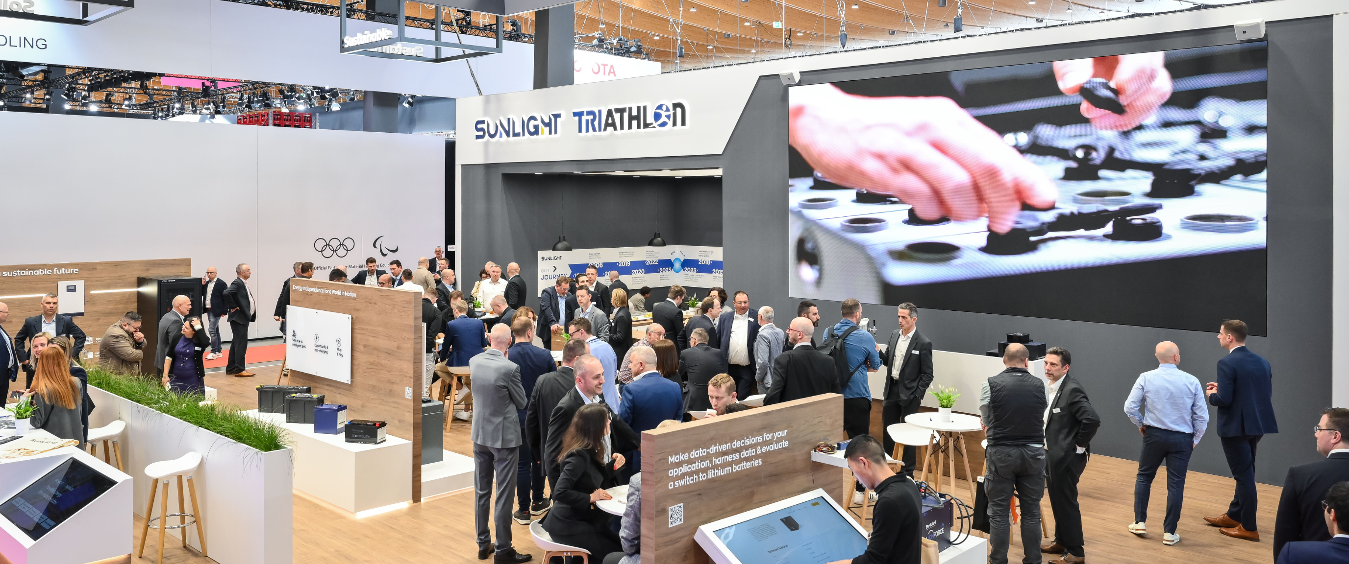 Sunlight Triathlon exhibition booth with visitors at trade show.
