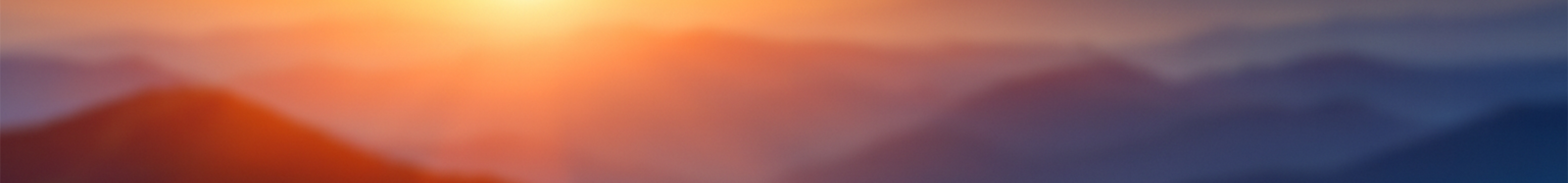 Sunrise over layered mountain landscape.
