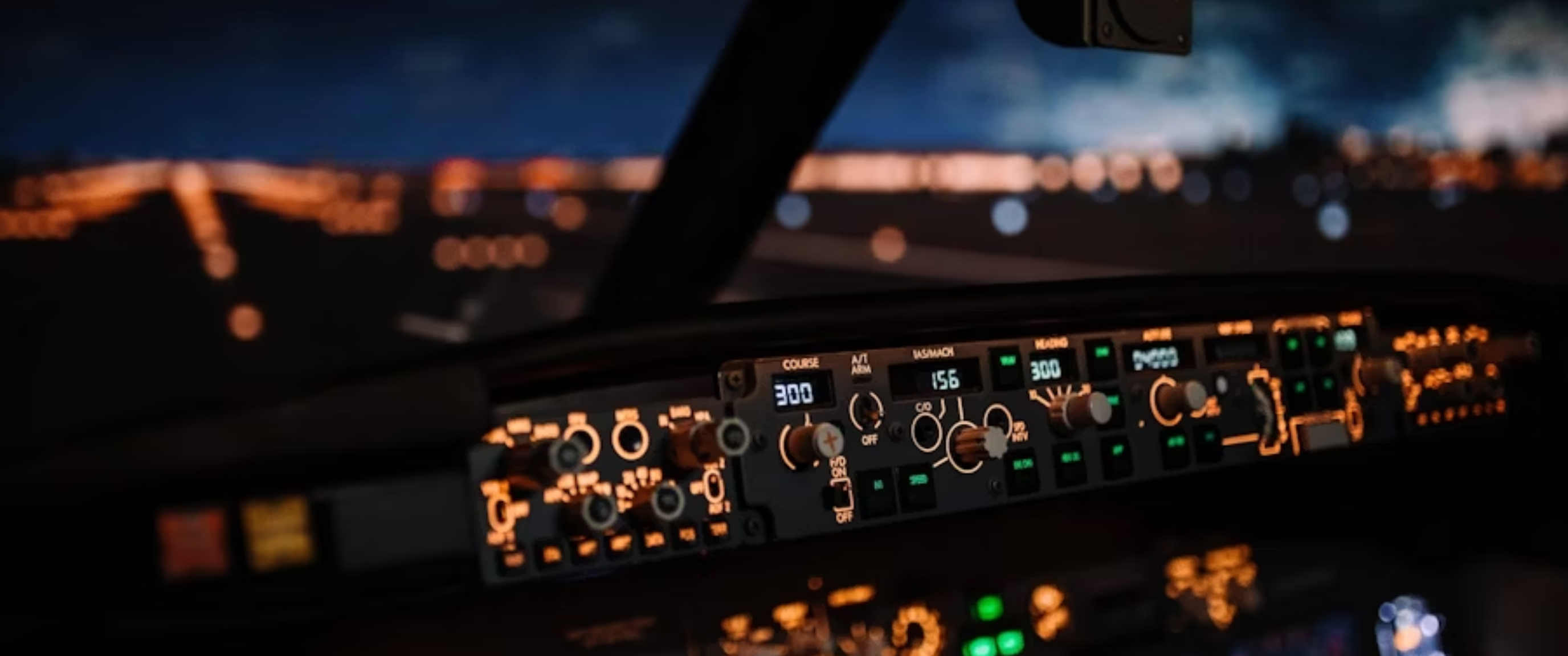 Aircraft cockpit controls illuminated at night.