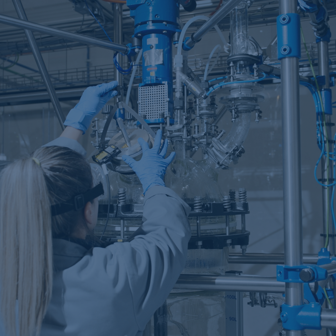 Technician adjusting industrial machinery in a production facility.