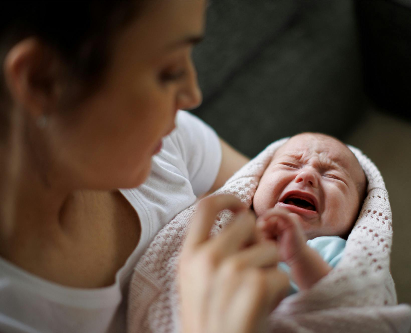 A woman holding a crying baby