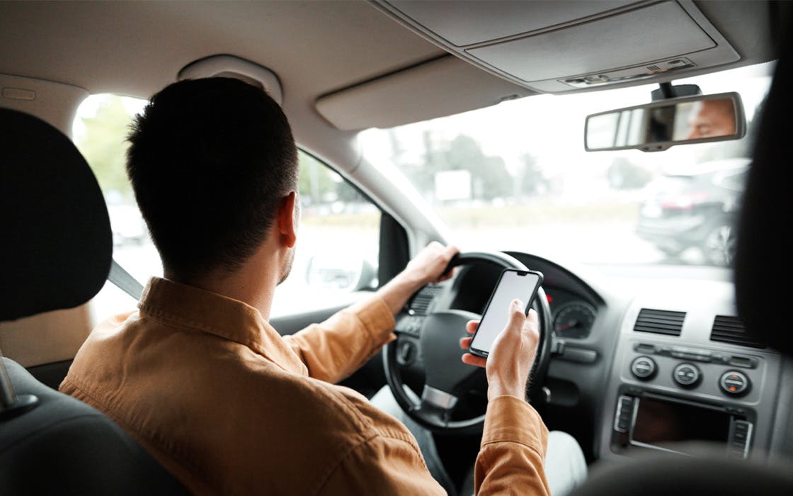 Man driving while on his phone