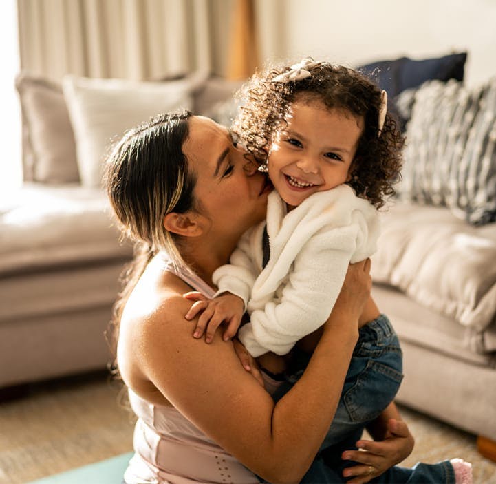 woman kissing a little girl on the cheek