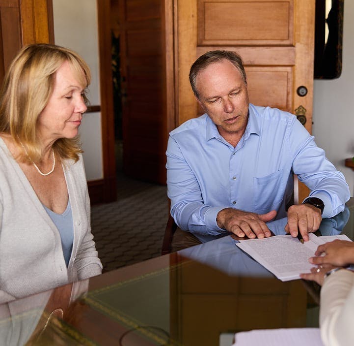 three people looking at documents