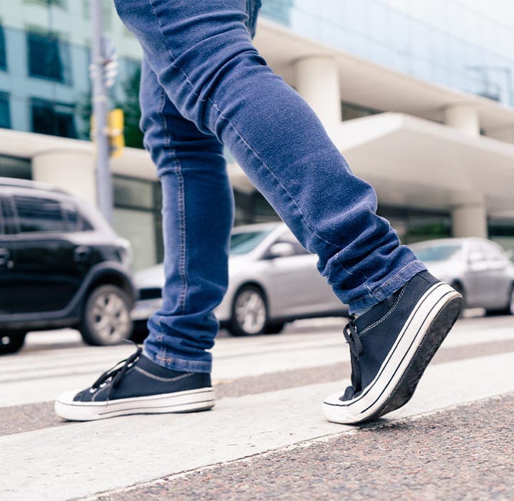 person walking across a road