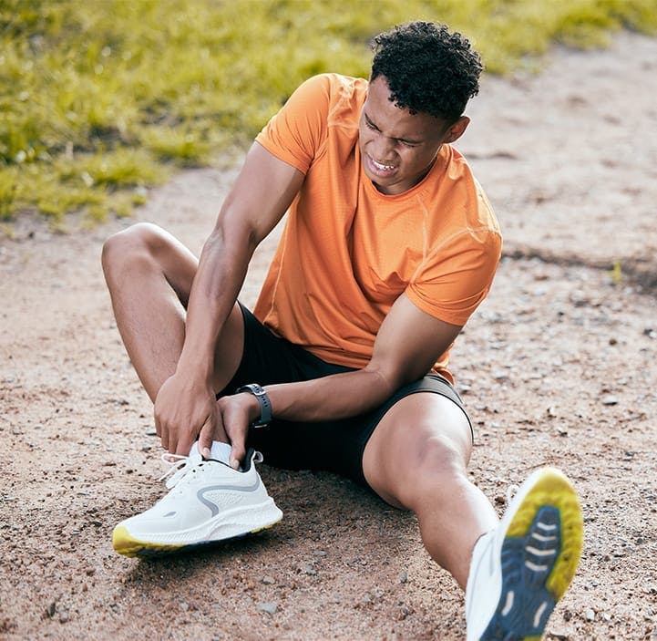 man holding his ankle in pain