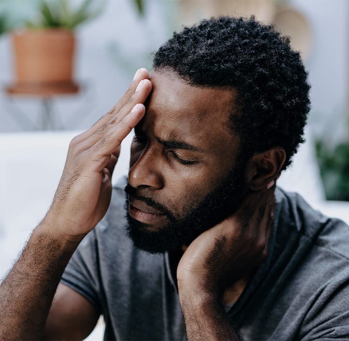 man holding his head in pain