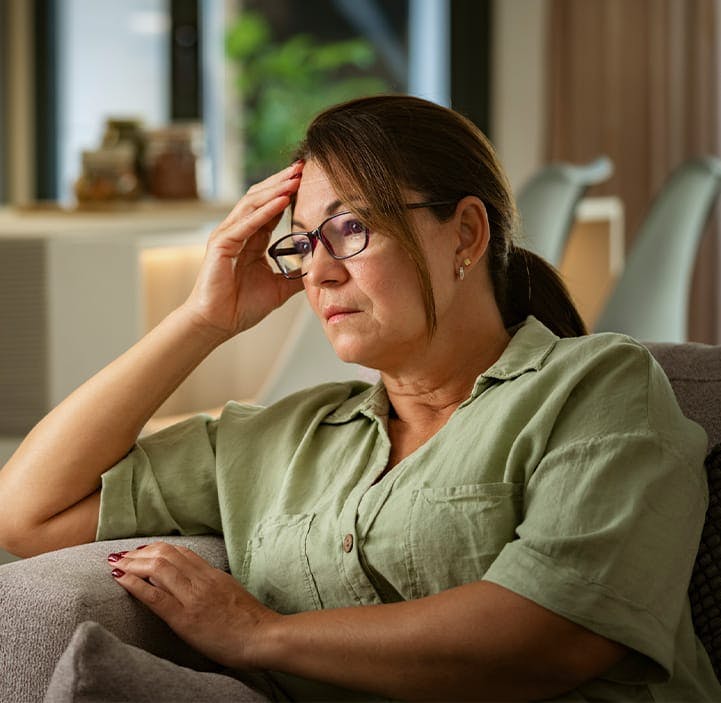 woman sitting on a couch looking sad