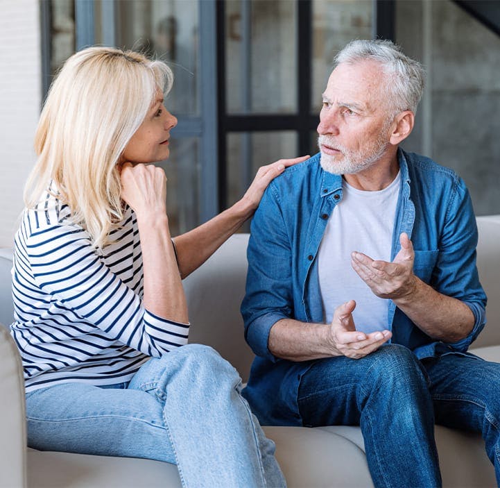 older man and woman talking on a couch