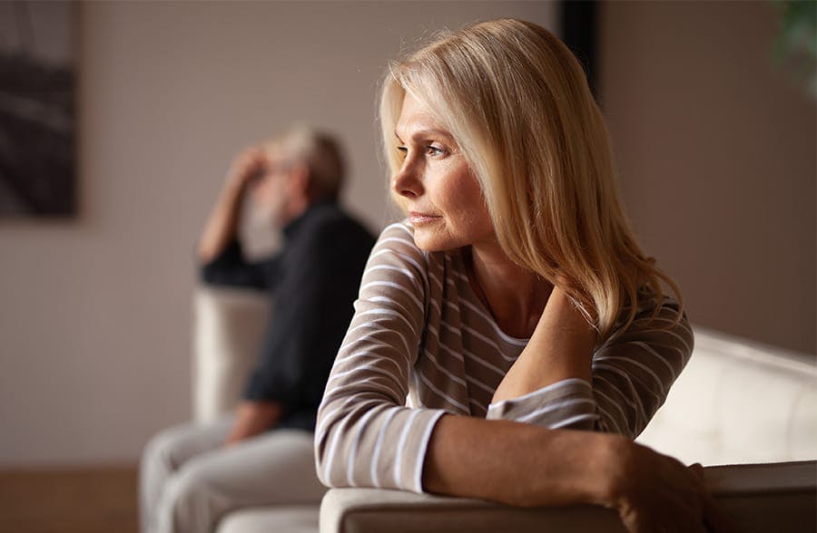 and and woman sitting away from each other on a couch