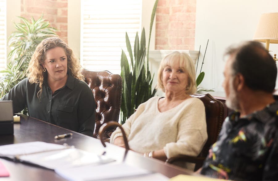 3 people at a table looking at each other