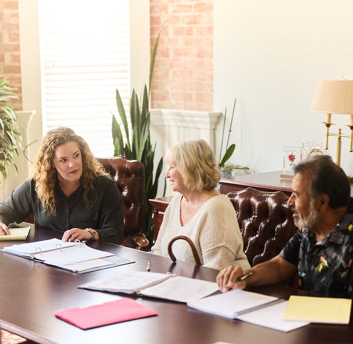 three people going over paperwork at a table