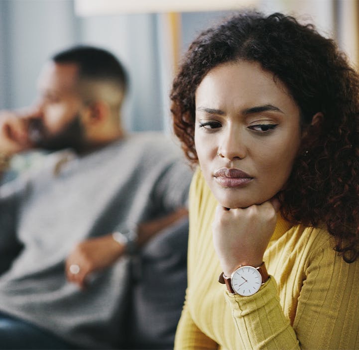 man and woman looking away from each other on a couch