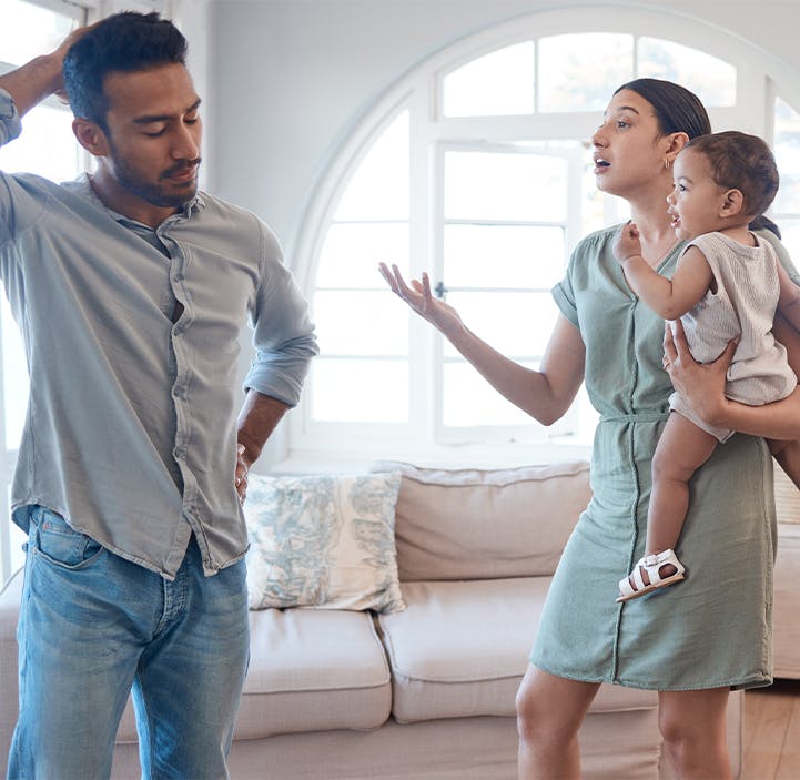 woman holding a baby arguing with a man