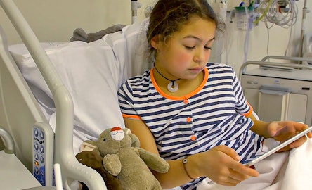Kindje in ziekenhuisbed met de cliniclowns app