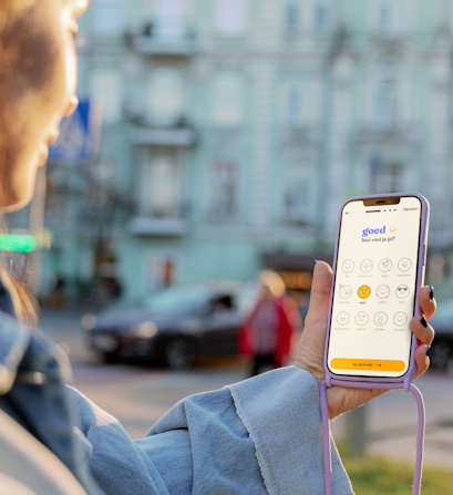 Een persoon met een telefoon in de hand waarom de feelee app geopend is
