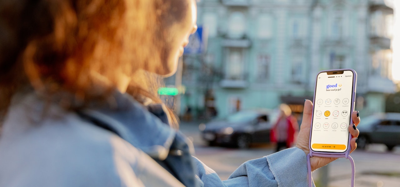 We kijken over de schouder van een jongere heen naar de telefoon in haar hand waar de feelee app op open staat