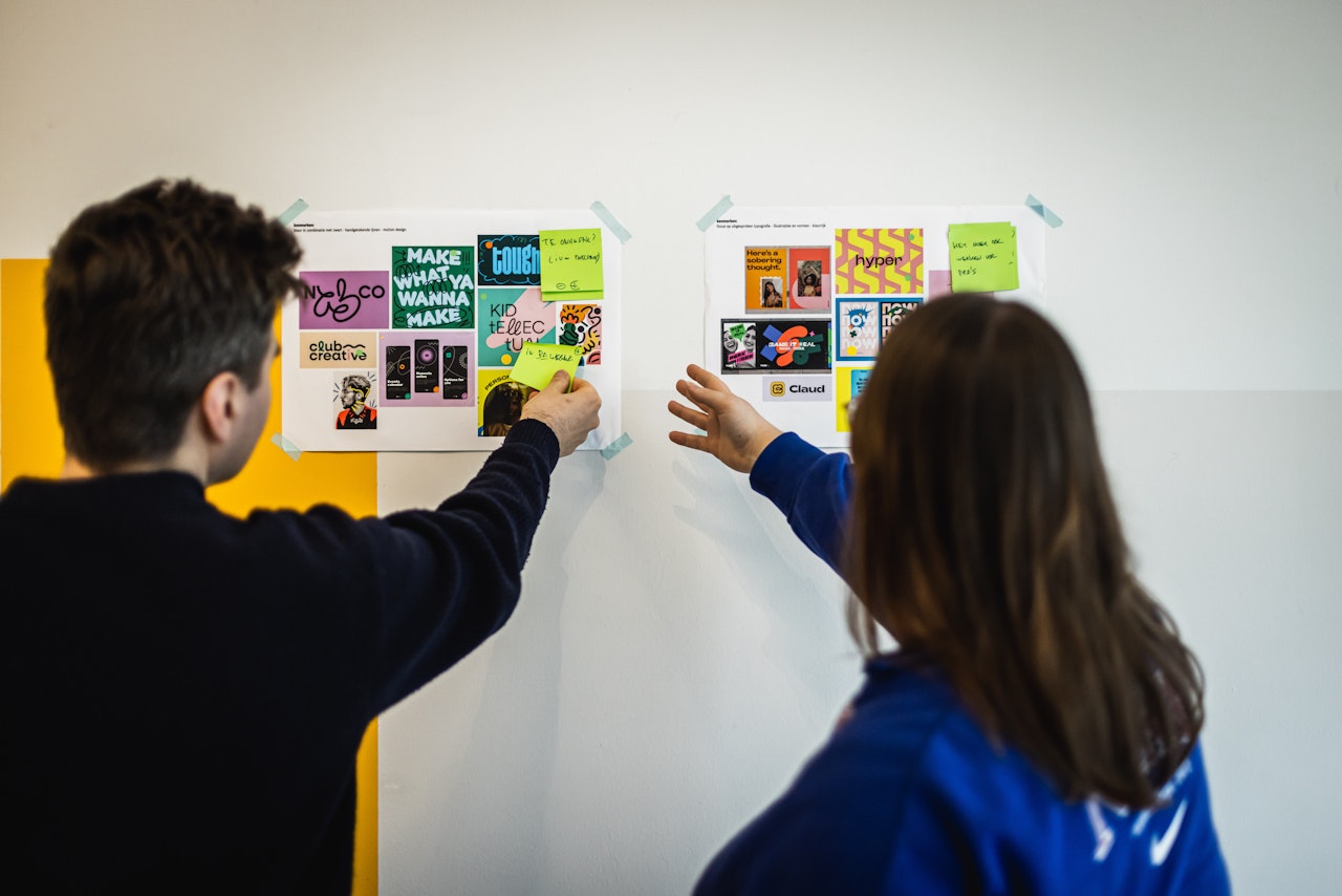 Diederik en Sarah brainstormen met moodboards op de muur.