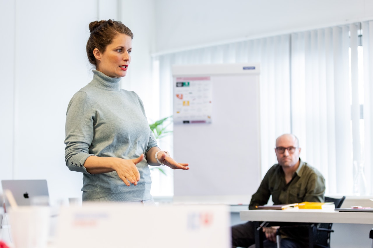 Susanne presenteert in een klaslokaal.