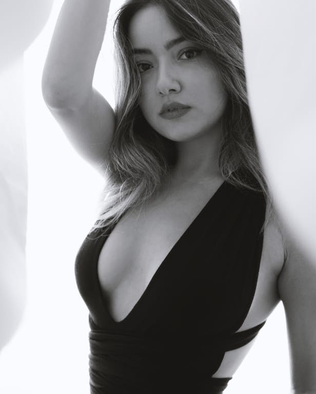 woman with makeup and low cut dress holding up a blanket