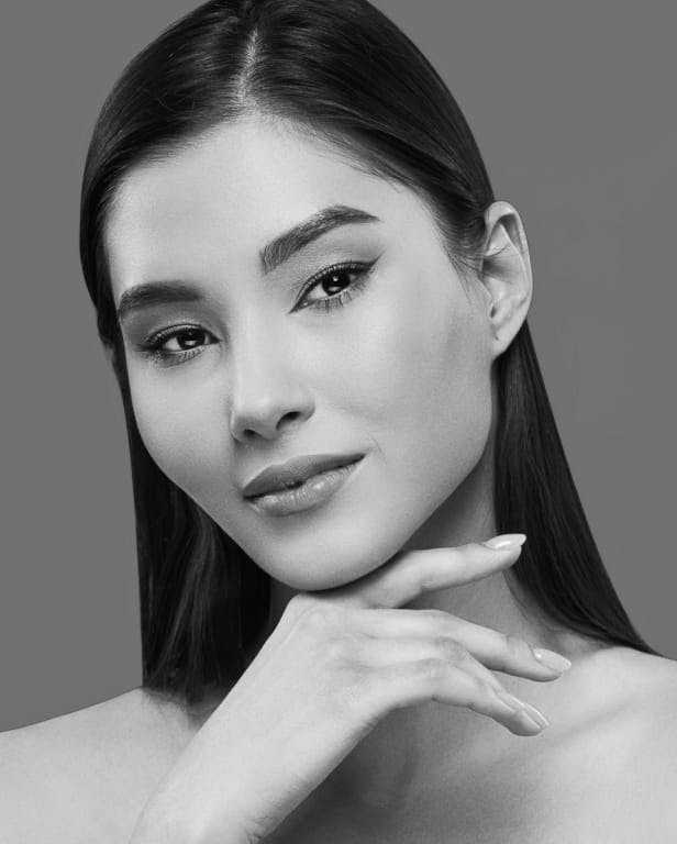 woman with chin resting on hand wearing mascara